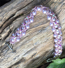 Load image into Gallery viewer, Soft and subtle, yet striking, this Swarovski Glass Pearl bracelet in Mauve is encased by matte pale lavender AB seed beads and topped with Swarovski Crystal Montees. This bracelet measures 7 5/8&quot;.