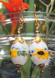 These handpainted oval ceramic earrings have Blackeyed Susans and tiny light blue violets and measure 1 1/2