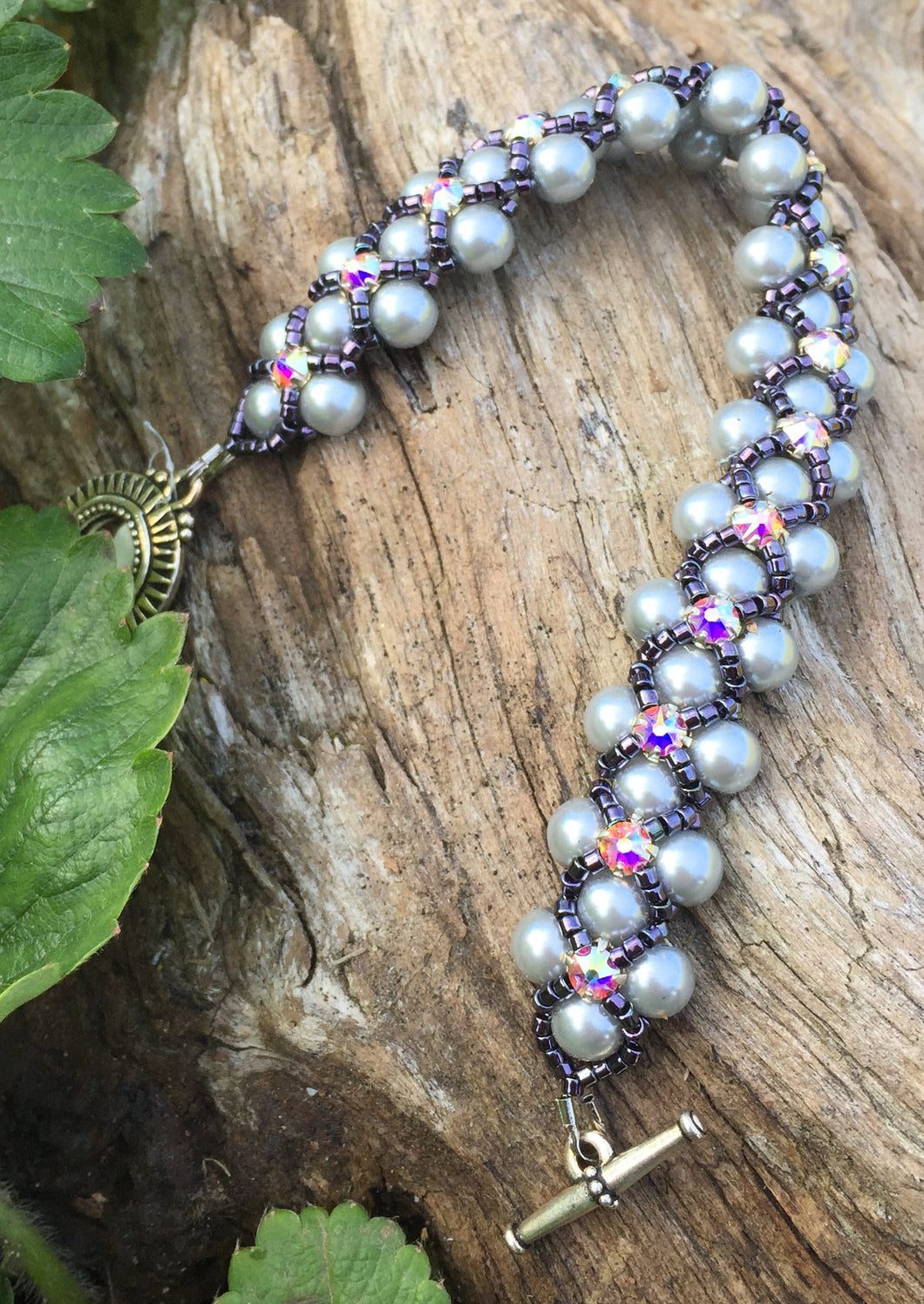 This Silver glass pearl and Dark Purple Delica Seed Bead bracelet is topped with Swarovki Crystal Montees and measures 7 1/4