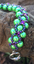 Load image into Gallery viewer, This Vivid Green glass pearl and Matte Iris seed bead bracelet is topped with Swarovski Purple Velvet Crystal Montees, and measures 7 1/2&quot;.