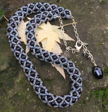 Load image into Gallery viewer, This fancy Black and Multi Iridescent Netted Treasure Necklace is held together by crystal and iridescent seed beads, which give it a subtle flash. The tail ends with three Swarovski crystals and a smooth black oval bead. This necklace is adjustable and can be worn from 20 1/2&quot; to 23&quot;.  