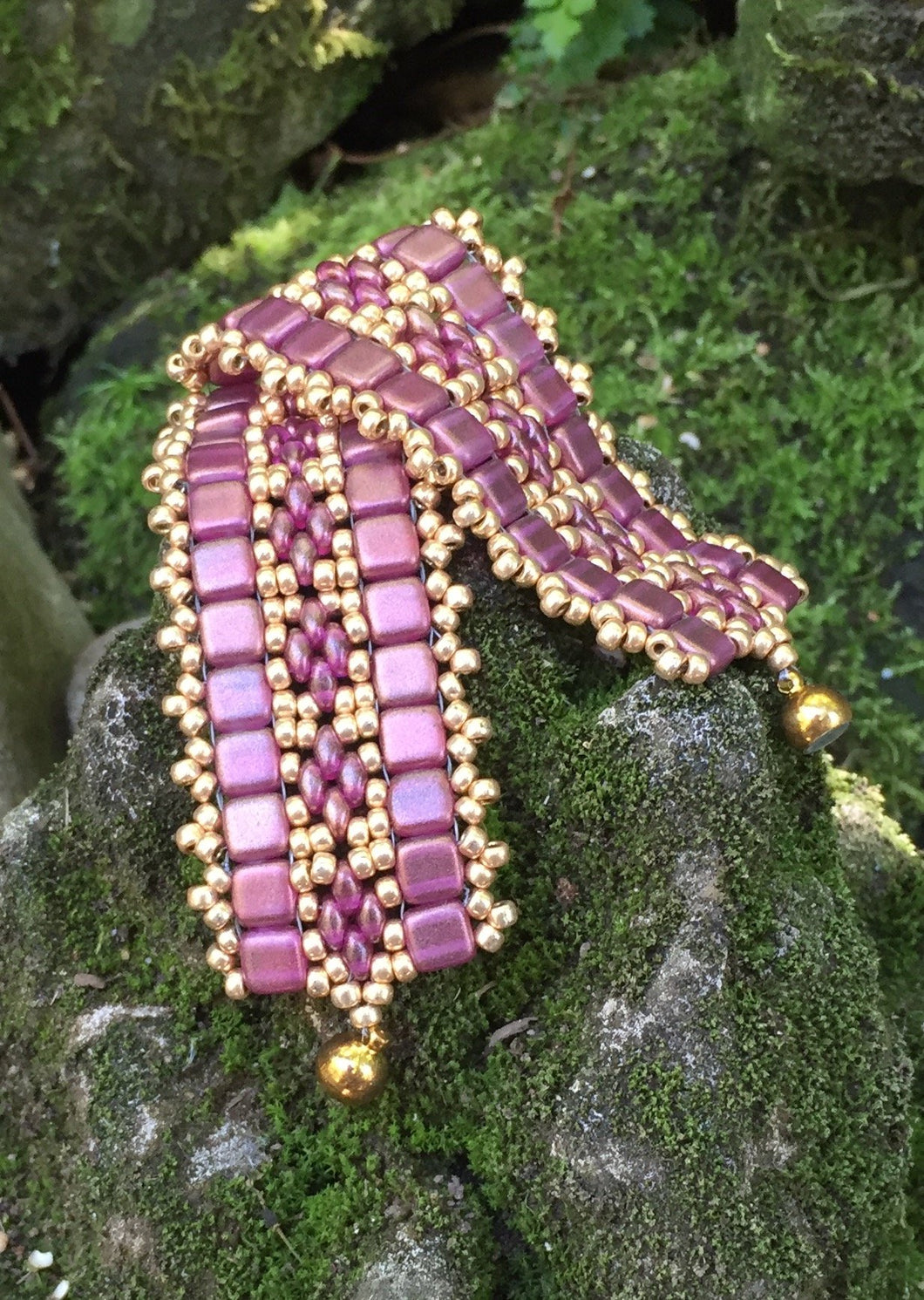 This bead woven bracelet combines gold toned Pink Czech Glass tiles with Pink and Gold glass beads and measures 6 3/4