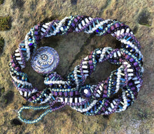 Load image into Gallery viewer, This meticulously woven helix necklace consists of Czech Glass beads in purple, black, green and cream and it ends with an iridescent Czech glass button clasp.  It is adjustable and can be worn between 15&quot; to 16 1/2&quot;.