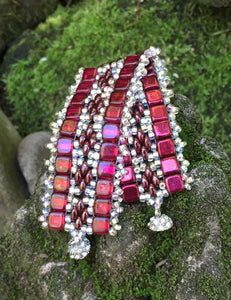 This bead woven bracelet combines Sherry Red Czech Glass tiles with Silver glass beads, a crystal adorned magnetic clasp and measures 6 3/8".