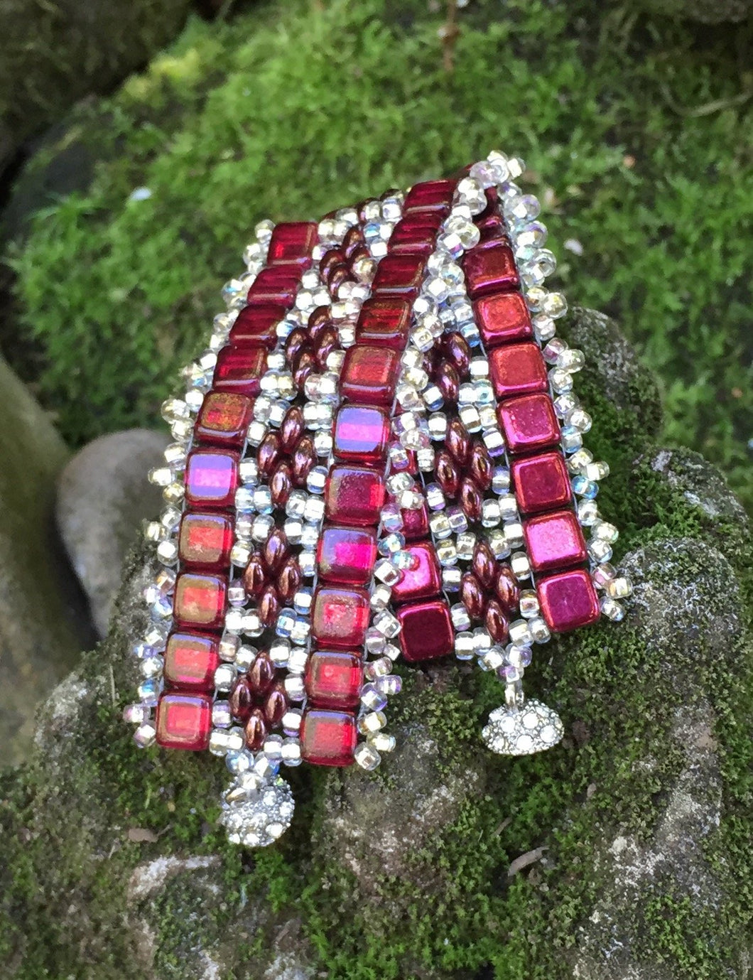 This bead woven bracelet combines Sherry Red Czech Glass tiles with Silver glass beads, a crystal adorned magnetic clasp and measures 6 3/8