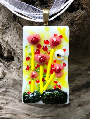 A Chickadee among the poppies in this glass pendant of Whites, Yellows, Reds and Corals with Iridescent dark Aventurine Green! This sweet floral pendant measures 1 3/4” by 1”. The White Organza and cotton cord is adjustable from 16 3/4” by 18 3/4”.
